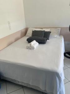 a large white bed with two towels on it at Loft inteiro, aconchegante. in Aracaju