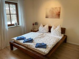 ein Schlafzimmer mit einem Bett mit blauen Handtüchern darauf in der Unterkunft FeWo Wünschendorf in Dürrröhrsdorf