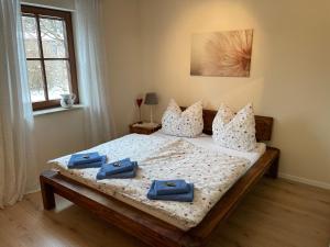 a bedroom with a bed with blue towels on it at FeWo Wünschendorf in Dürrröhrsdorf