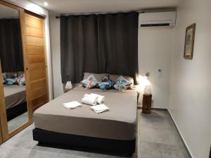 una camera da letto con un letto e asciugamani di Le Fare Cosy Kiwi et le Fare Cosy Tiki a Faaa