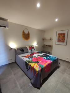 una camera da letto con un letto con una coperta colorata di Le Fare Cosy Kiwi et le Fare Cosy Tiki a Faaa