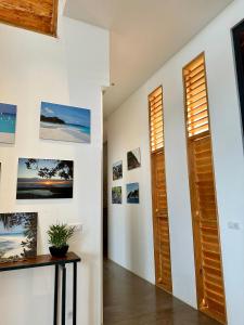 a hallway with a table and pictures on the wall at PASSOT HILLS in Nosy Be