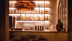 a bar with a lot of bottles on the wall at Anacardier Privé Hotel in Atins