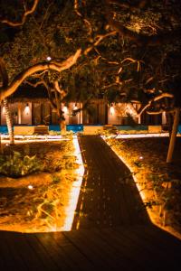 Una pasarela en un parque por la noche con luces en Anacardier Privé Hotel, en Atins
