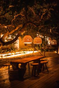 un tavolo in legno con sgabelli in un parco di notte di Anacardier Privé Hotel ad Atins