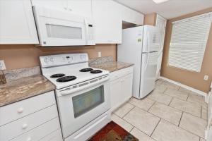 eine Küche mit weißen Geräten und weißen Schränken in der Unterkunft SeaCrest 304 condo in Fort Walton Beach