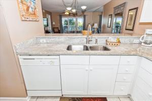 eine Küche mit weißen Schränken und einem Waschbecken in der Unterkunft SeaCrest 304 condo in Fort Walton Beach