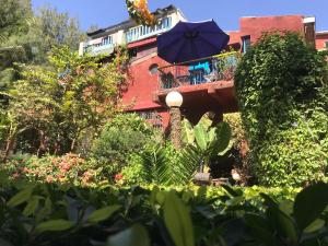 a building with a balcony with a blue umbrella at Fabuleuse Villa Keur Bibou in Dakar