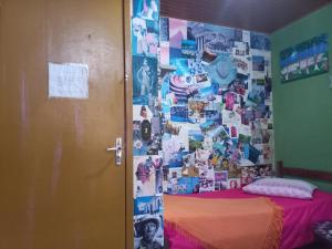 a bedroom with a wall covered in pictures at Casa Hostel Mosaicos DyA in Florianópolis