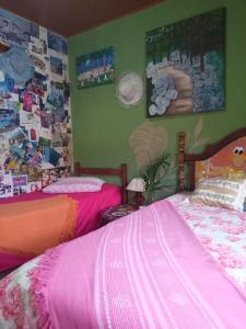a bedroom with two beds and a wall with pictures at Casa Hostel Mosaicos DyA in Florianópolis