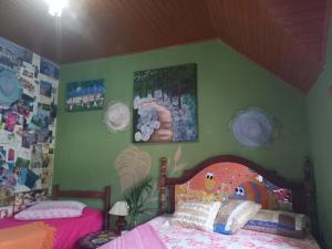 a bedroom with a bed and a green wall at Casa Hostel Mosaicos DyA in Florianópolis