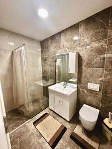 een badkamer met een toilet, een wastafel en een douche bij Lovely Family Apartment in Ferizaj