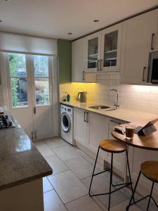 a kitchen with a sink and a washing machine at Kemp Town apartment in Brighton & Hove