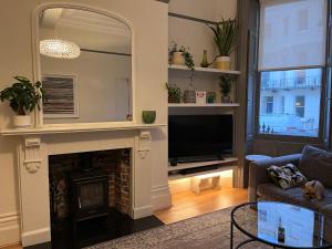 a living room with a fireplace and a mirror at Kemp Town apartment in Brighton & Hove