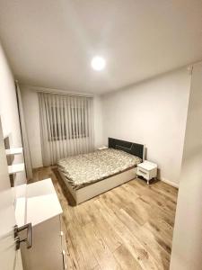 a small bedroom with a bed and a window at Lovely Family Apartment in Ferizaj