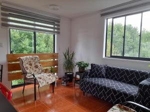 un salon avec un canapé et une chaise dans l'établissement Apartamentos Vera Ribbeck, à Valdivia