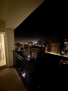 a view of a city at night from a balcony at Lovely Family Apartment in Ferizaj