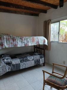una camera da letto con un letto a castello e una sedia di Los Caranchos I a Cuchilla Alta
