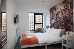 - une chambre avec un lit et des serviettes dans l'établissement Versatile Retreat-Mid/Long Stay%, à Liverpool