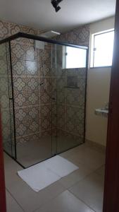 a shower with a glass door in a bathroom at Pousada Sons do Silêncio in Socorro
