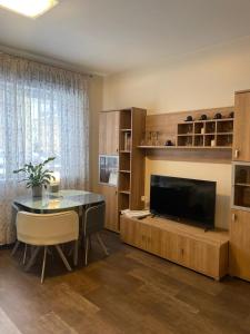 een woonkamer met een eettafel en een televisie bij Studio apartamenti Cēsis in Cēsis