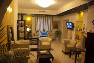 a waiting room with chairs and a tv in a salon at Hotel San Paolo in Manduria