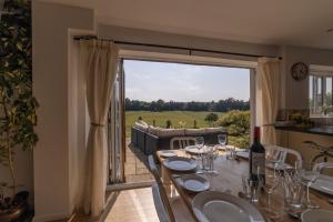 comedor con mesa y ventana grande en Holly Cottage, Surrey Hills, en Cranleigh