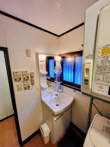 a small bathroom with a sink and a mirror at Powder Peak Misorano Free courtesy car in Hakuba