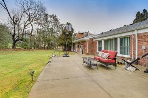 un patio con un sofá rojo y un columpio en Family-Friendly Bloomfield Hills Home with Patio! en Bloomfield Hills