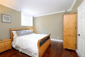 ein Schlafzimmer mit einem Holzbett und einem Fenster in der Unterkunft Upscale Character Home with Luxurious Amenities in Victoria