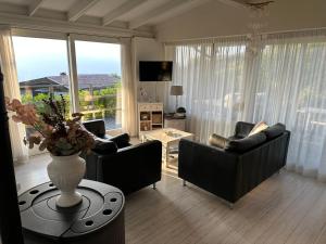 a living room with couches and a vase of flowers on a table at Casita di Ellinor in Tignale