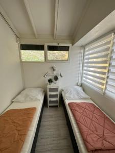 two beds in a small room with two windows at Casita di Ellinor in Tignale +13 photos