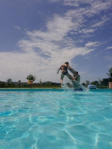 IL CUORE DEL CONERO - CASALE CON PISCINA, Natura e Relax في كاميرانو: رجل يركب دلفين في تجمع ماء