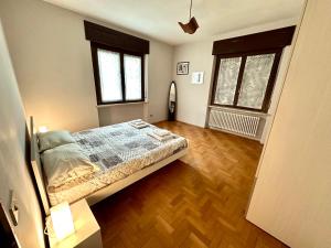 a bedroom with a bed and two windows at Gurej Casa Vacanze in Carema