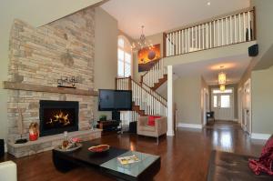 a living room with a fireplace and a stone wall at Beautiful ski chalet in the blue mountains with gas fireplace and community pool in Collingwood