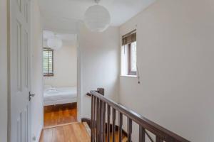 einen Flur mit einer Treppe und einer Badewanne in einem Zimmer in der Unterkunft Quiet & Secluded St Albans House in St Albans