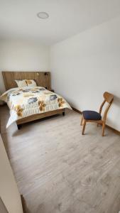 a bedroom with a bed and a chair at la terraza departamentos 301 in Cuenca