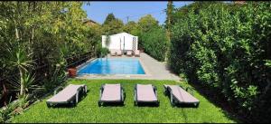 uma piscina com duas espreguiçadeiras na relva ao lado em Casa da Vovó (Casa do Tapado) em Amarante