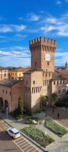 a building with a clock tower in a city at Torrione view apartment in Spilamberto