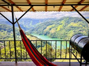 een hangmat in een kamer met uitzicht op een rivier bij Ecohotel Sereni Norcasia in Samaná