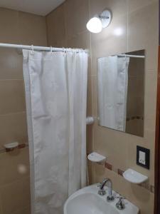 a bathroom with a white shower curtain and a sink at Departamento San José IV- Villa Carlos Paz in Villa Carlos Paz