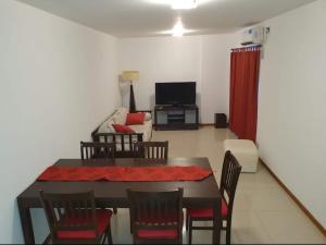 Departamento San José IV- Villa Carlos Paz في فيلا كارلوس باز: غرفة معيشة مع طاولة وكراسي وأريكة