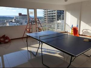 - Mesa de ping pong en una habitación con balcón en Departamento San José IV- Villa Carlos Paz en Villa Carlos Paz