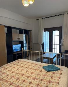 a bedroom with a bed and a table and a television at Downtown Studio Calea Victoriei in Bucharest
