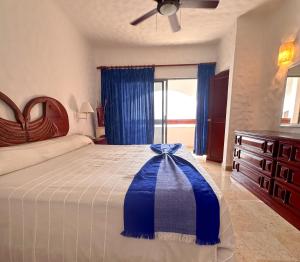 een slaapkamer met een bed met een blauwe boog erop bij Hotel Quijote Inn in Mazatlán