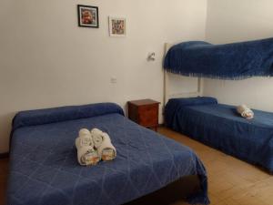 ein Schlafzimmer mit zwei Betten mit Schuhen auf dem Bett in der Unterkunft Che Neco in Necochea + 10 Fotos