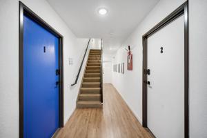 a hallway with a blue door and stairs at Beautiful Work Stay Retreat in Pueblo Near Downtown in Pueblo