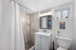 a white bathroom with a toilet and a shower at Beautiful Work Stay Retreat in Pueblo Near Downtown in Pueblo