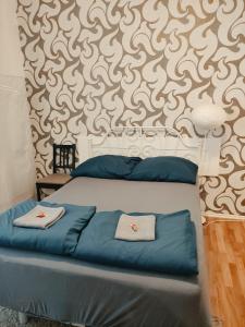 a bedroom with a bed with blue pillows and a wall at Gallys Apartments in Prague