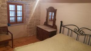 a bedroom with a bed and a mirror at Mediterranean stone house Ucović in Gruda